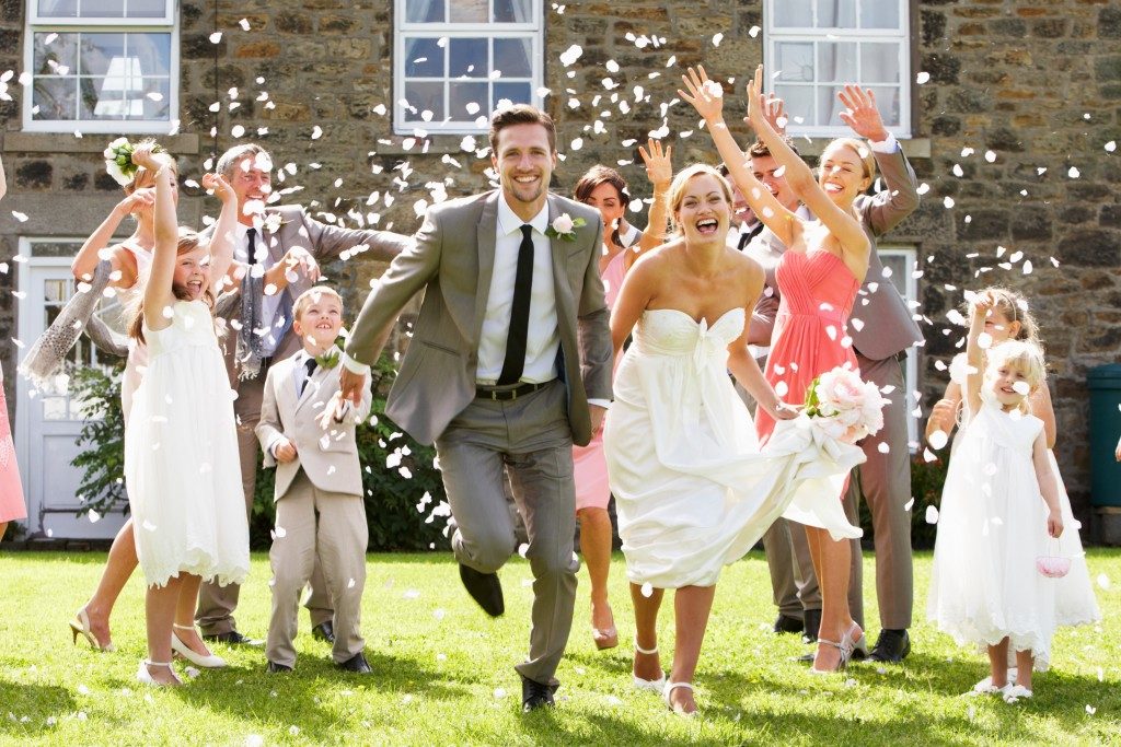 Guests throwing confetti over newly weds