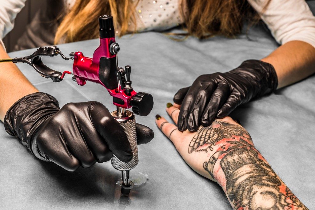 Artist tattooing a woman