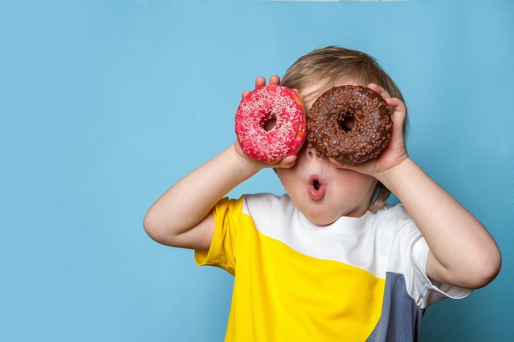 Kid holding two doughnuts