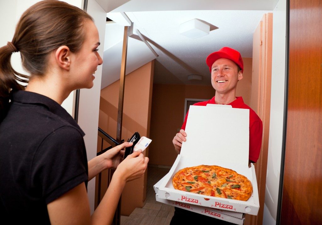Woman paying the pizza delivery guy