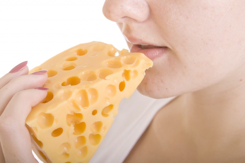 girl biting cheddar cheese