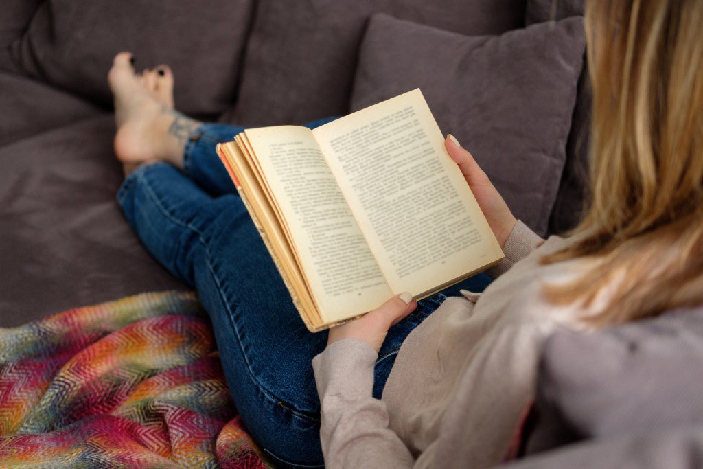 Female reading a book on the couch