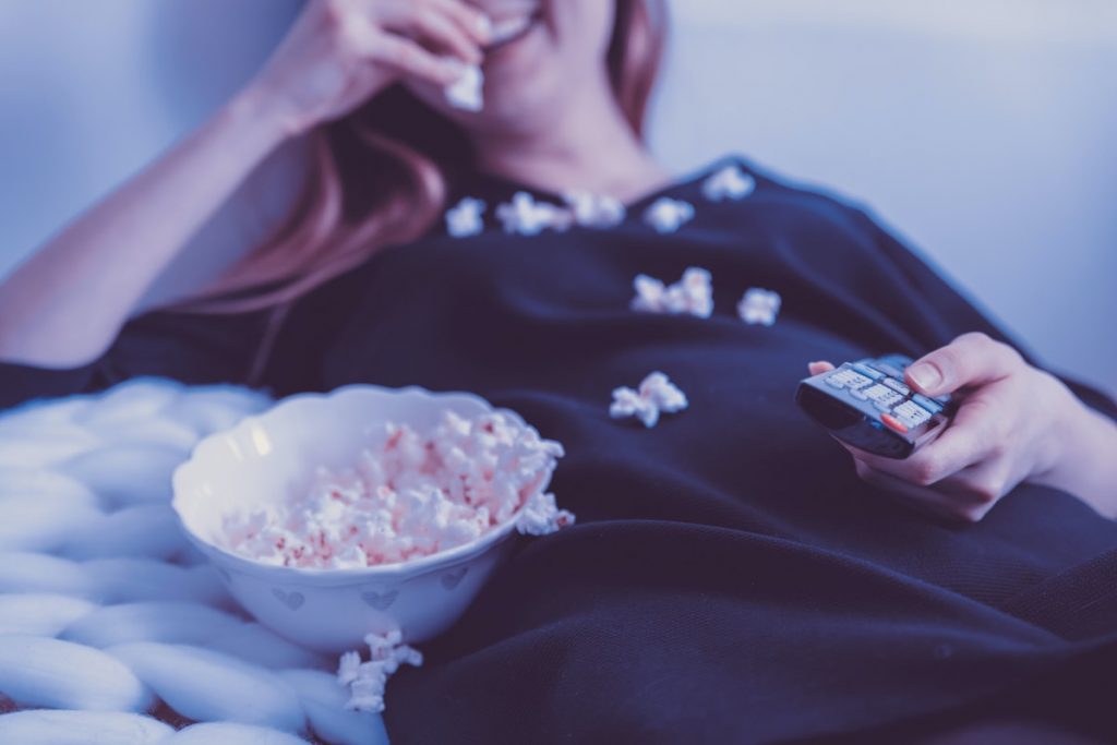 woman eating popcorn while watching a movie