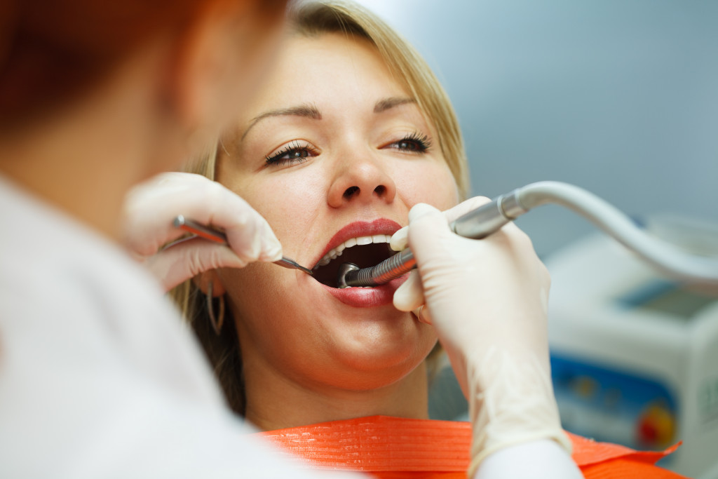 a woman getting teeth cleaned by a dentist