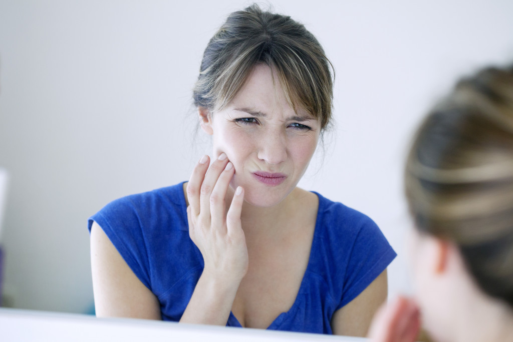 woman looking at the mirror toothache