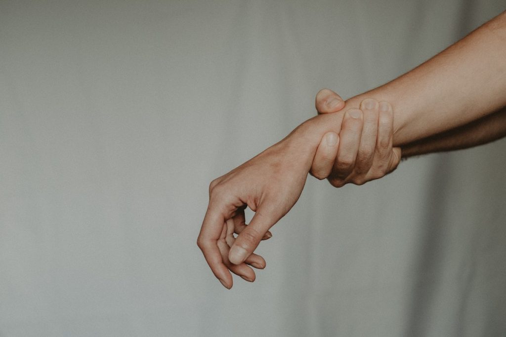 Unrecognizable person holding hand of partner abusively