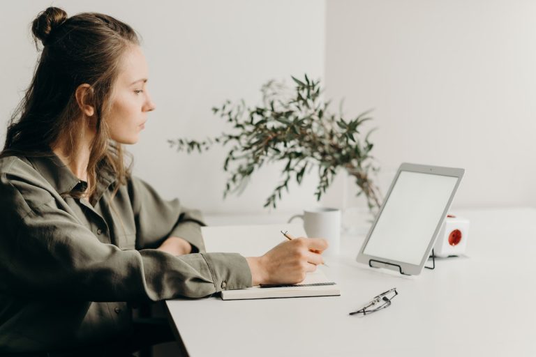 woman-in-gray-coat-using-white-laptop-computer