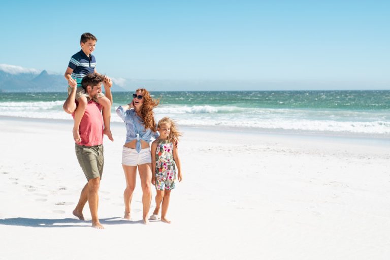 family walking by the beach during a sunny day