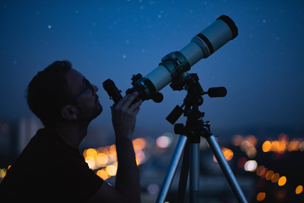 A man star gazing using a telescope