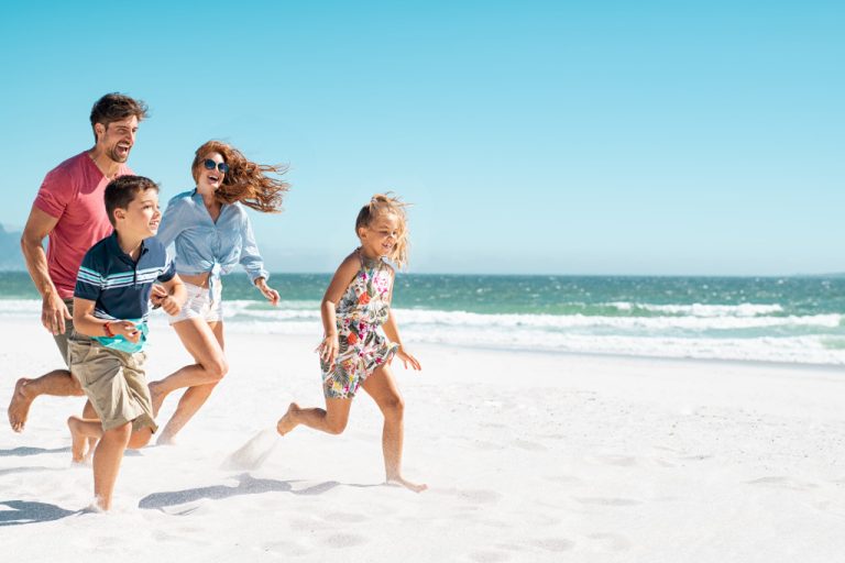 a family running at the beach