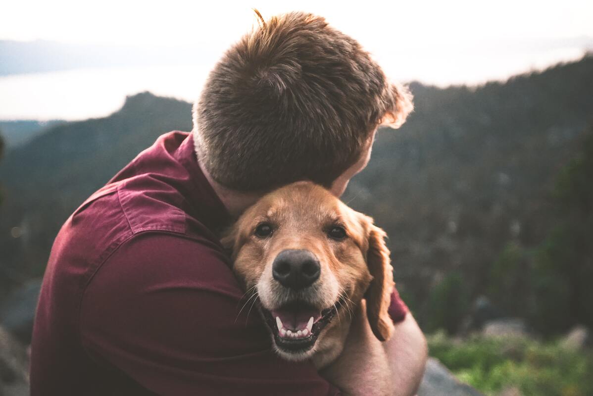 man hugging his pet dog