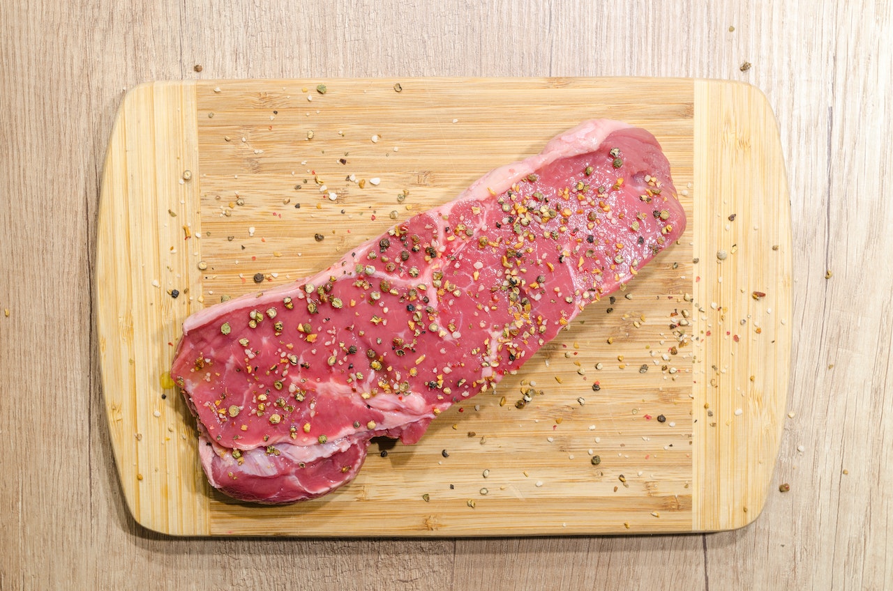 raw steak sprinkled with salt and pepper