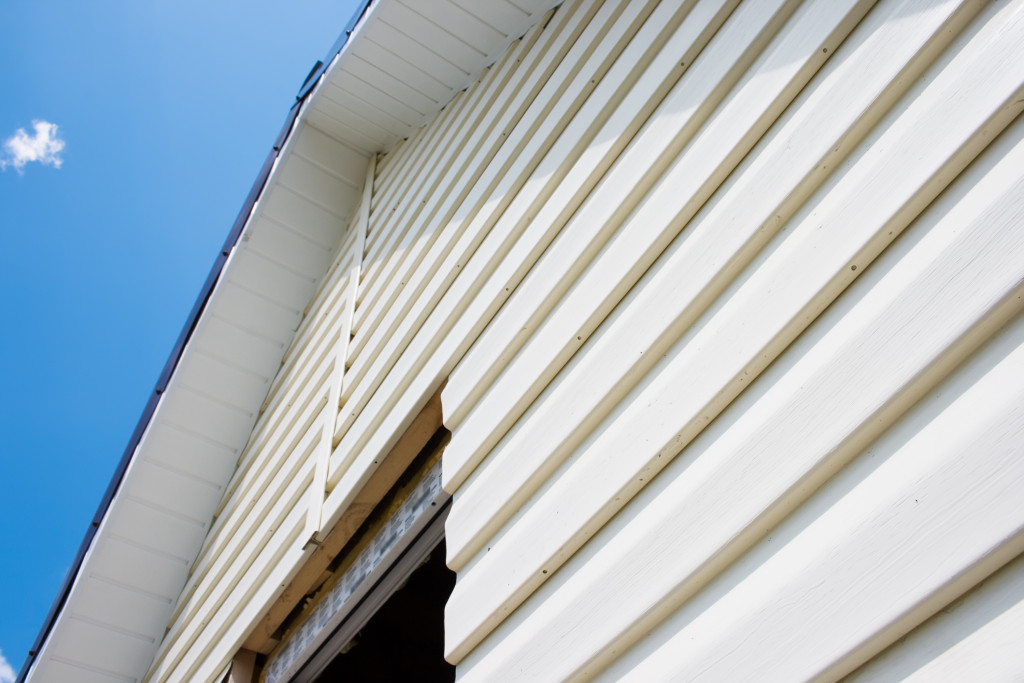 a plain white siding in a house with blue sky as background on the side